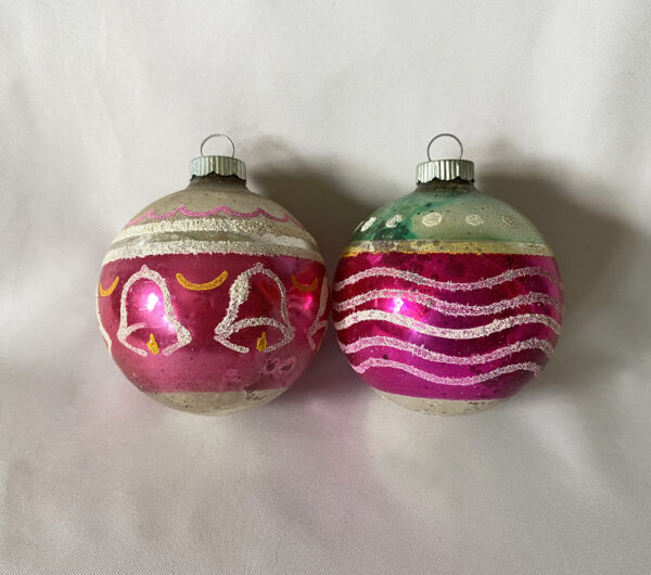 Vintage Shiny Brite Glass Christmas Ornaments from the 1950s with white mica designs over magenta bands of color, one with bells and one with dots and curvy stripes, two ornaments sold as a lot.